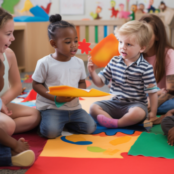 An image of children sitting around a table, holding colorful alphabet blocks and pointing to different letters. The alt text could be: "Children engaging in hands-on alphabet activities, which helps with letter recognition and language development."